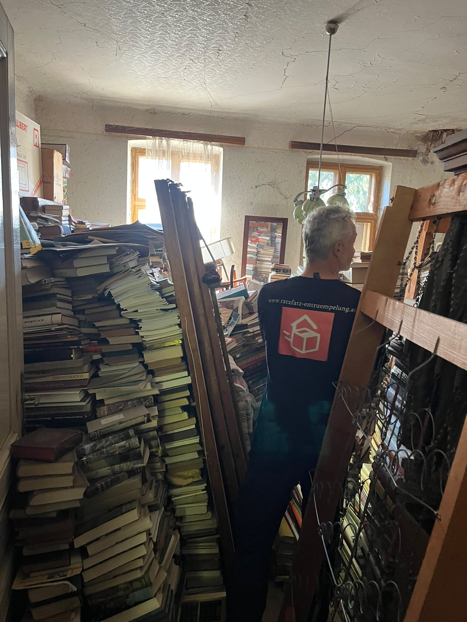 Bis zur Decke gestapelte Bücher in einer zu räumenden Wohnung